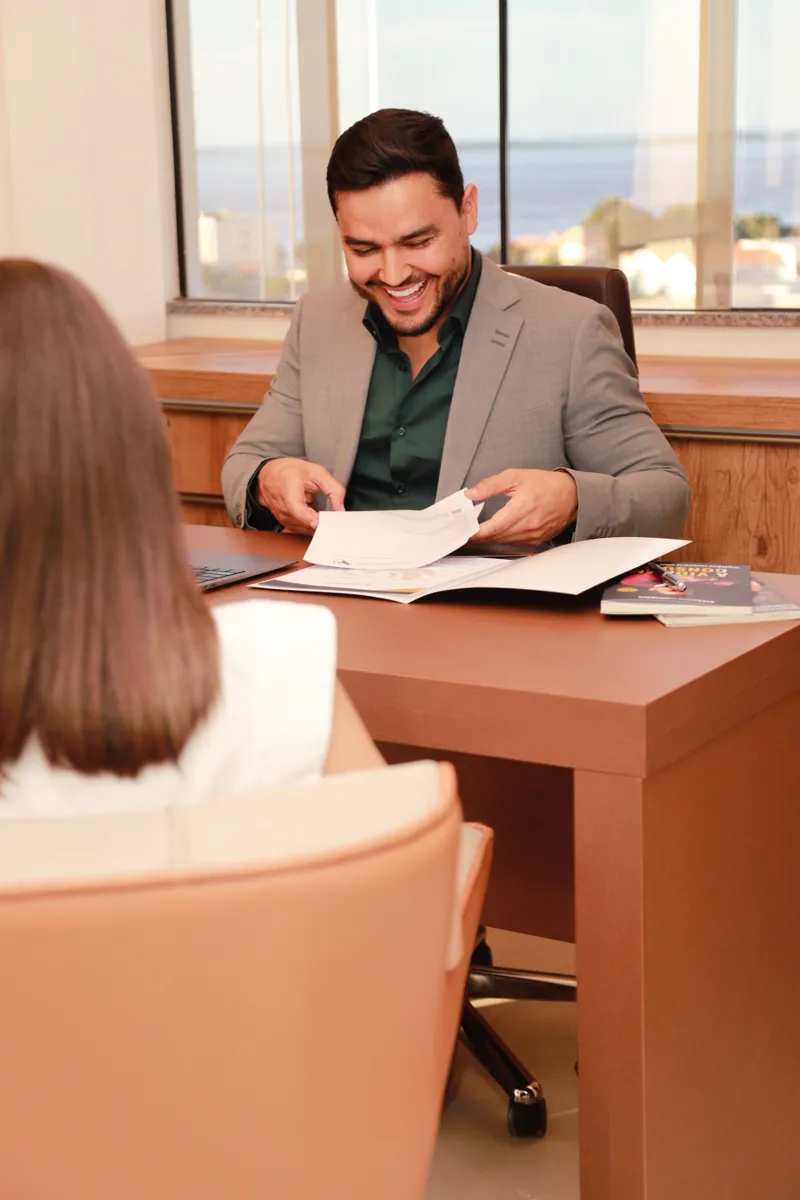 Dr. Bernardo Guimarães em consulta, lendo exames à mesa